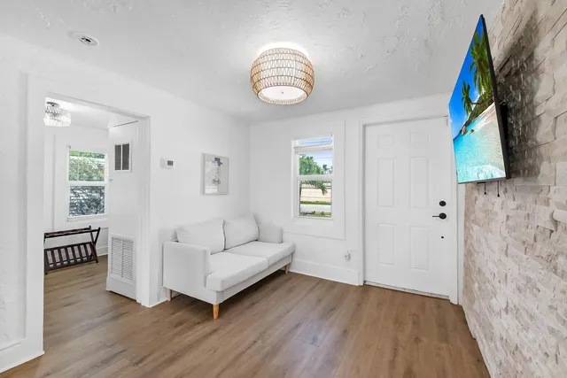 a living room with furniture and a wooden floor