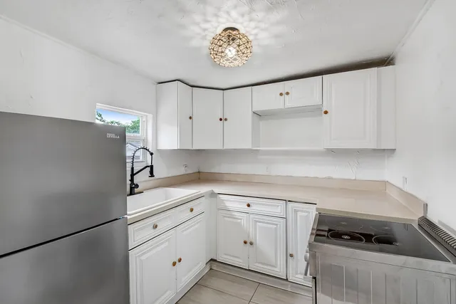 a kitchen with white cabinets and white appliances
