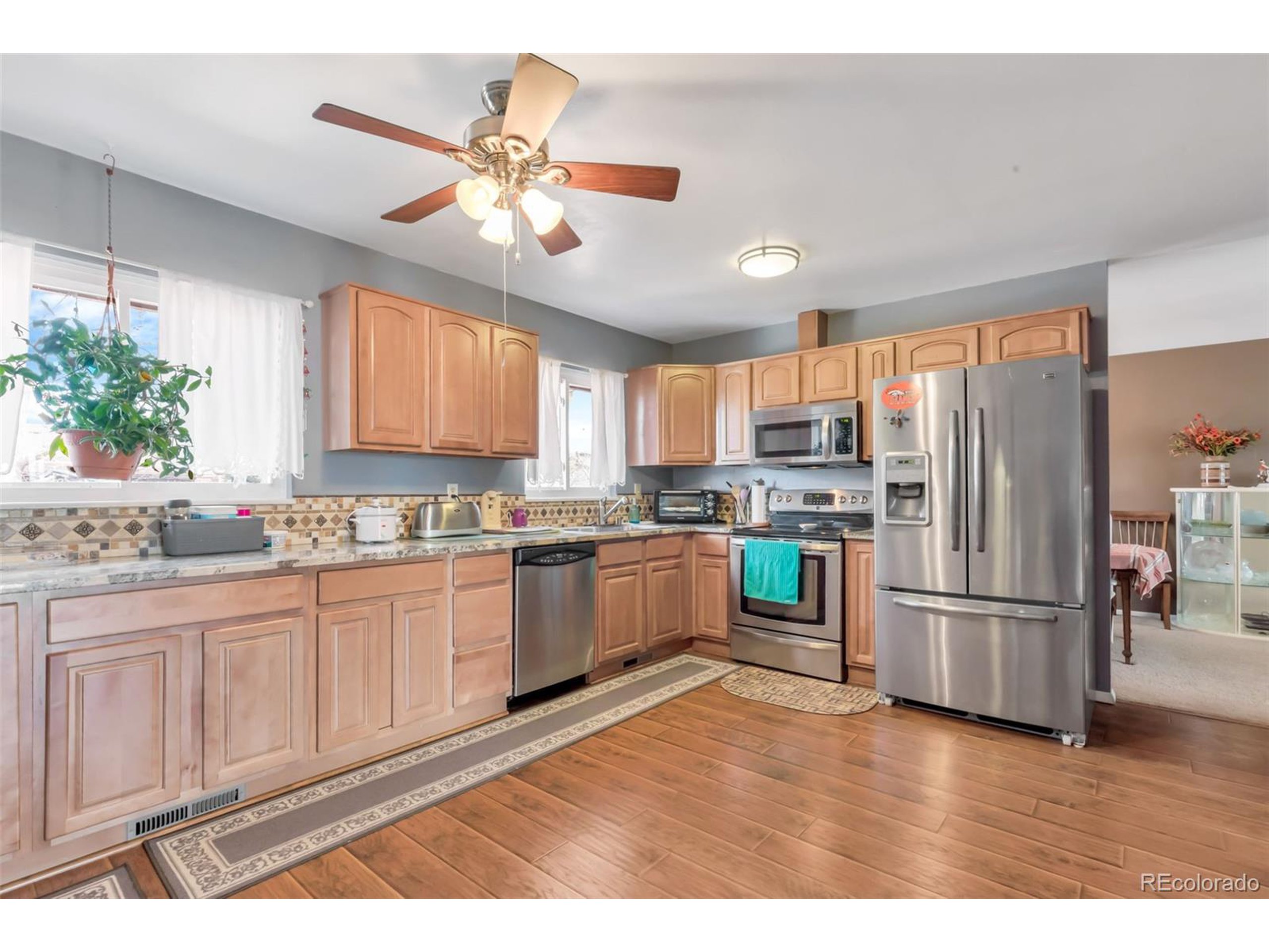 a kitchen with granite countertop stainless steel appliances a sink cabinets and a window