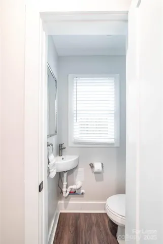 a bathroom with a sink a toilet and a window