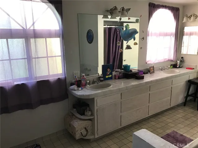 a en suite bathroom with a double vanity sink and a mirror