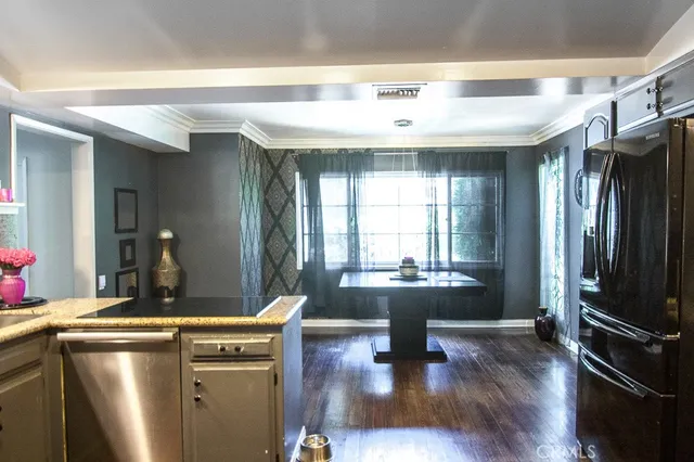 a kitchen with a refrigerator and wooden floor