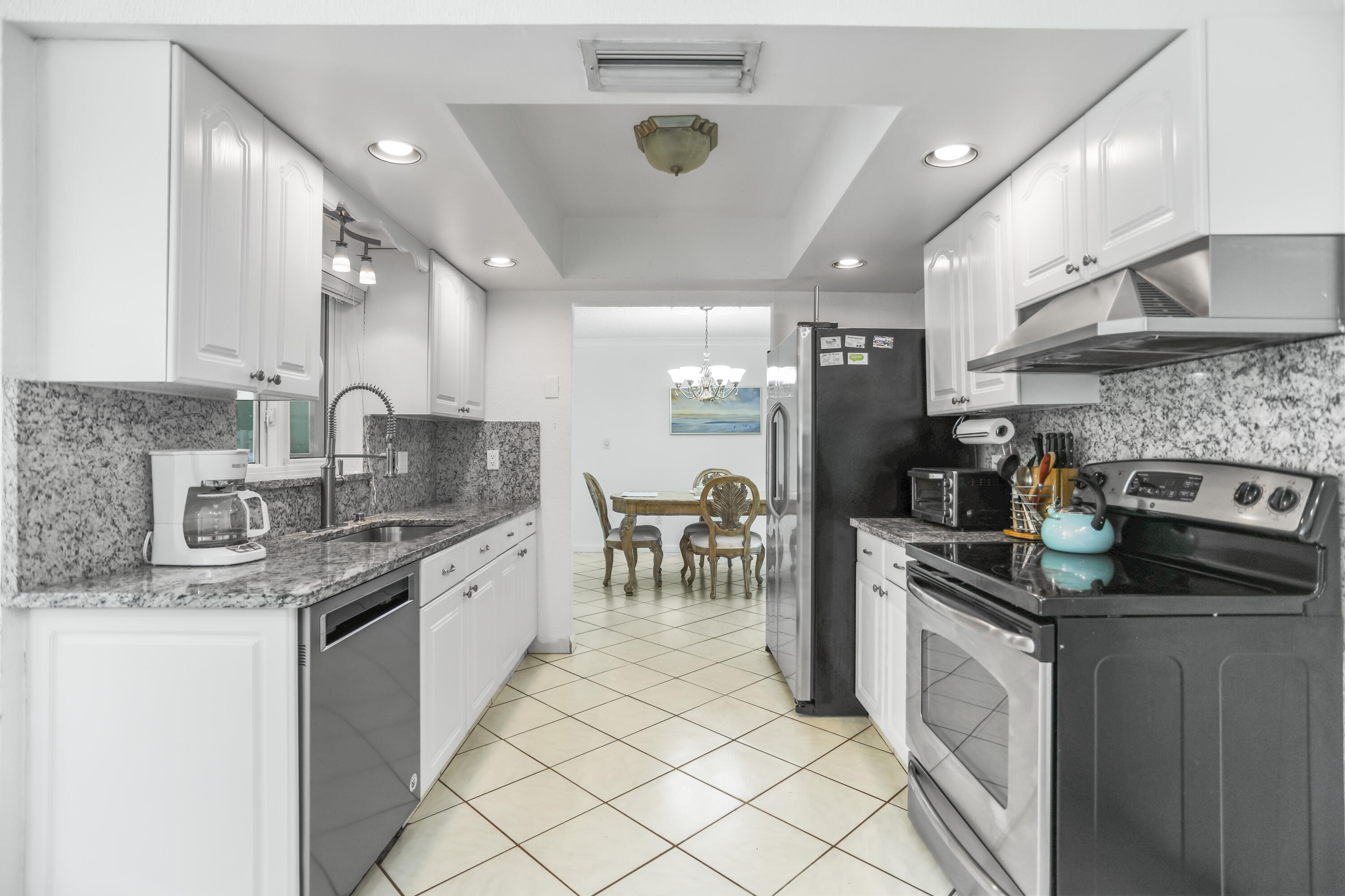 22682 Southwest 65th Avenue Boca Raton, FL 33428 - Photo 11 of 58 a kitchen with stainless steel appliances granite countertop a sink and cabinets