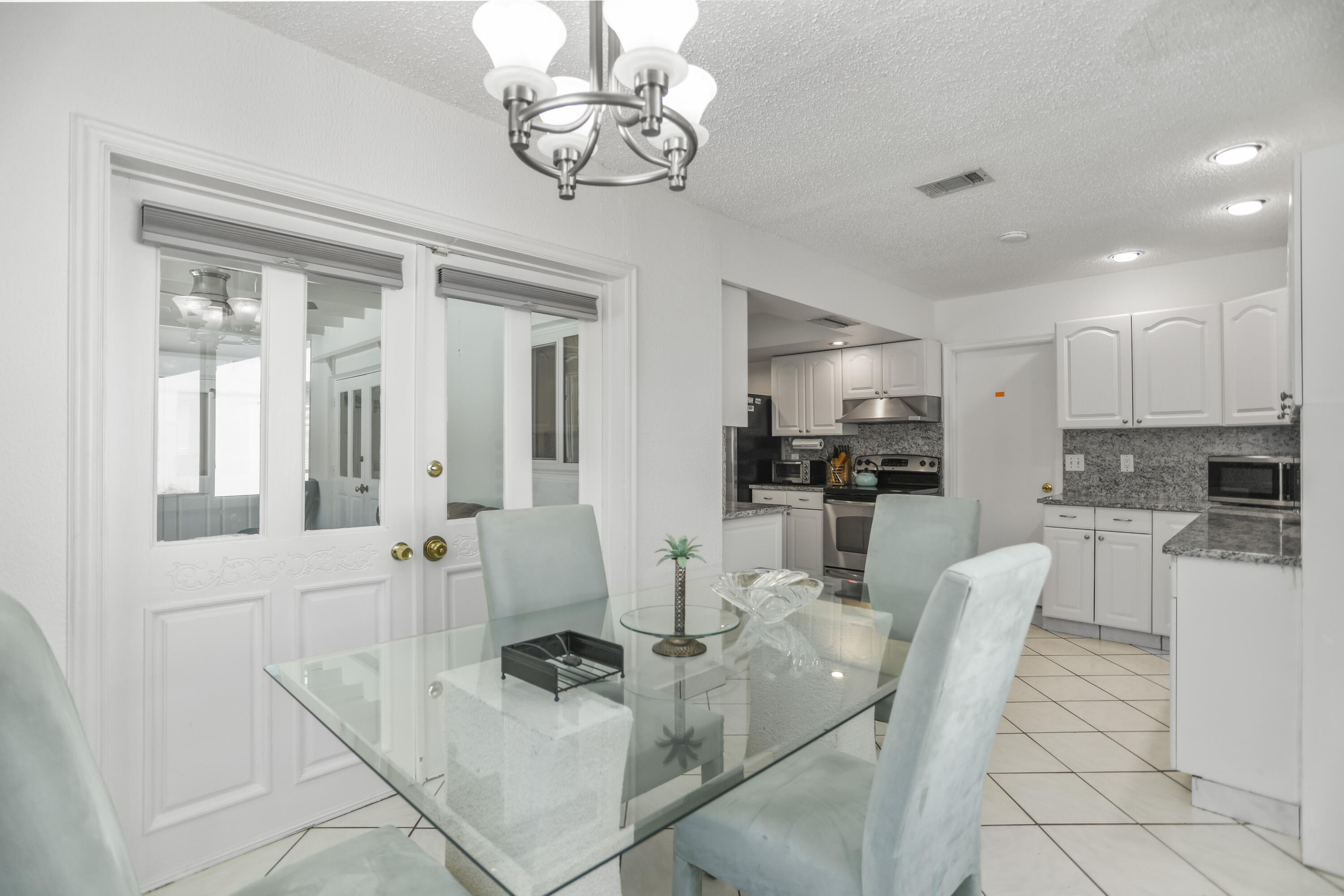 22682 Southwest 65th Avenue Boca Raton, FL 33428 - Photo 19 of 58 a view of a dining room and livingroom with furniture wooden floor a chandelier