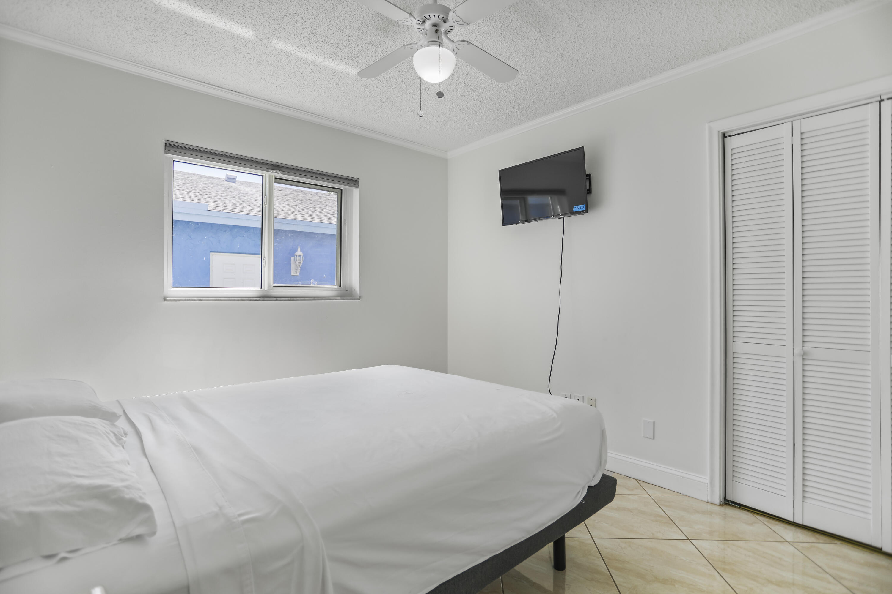 22682 Southwest 65th Avenue Boca Raton, FL 33428 - Photo 24 of 58 a bedroom with a bed and a chandelier