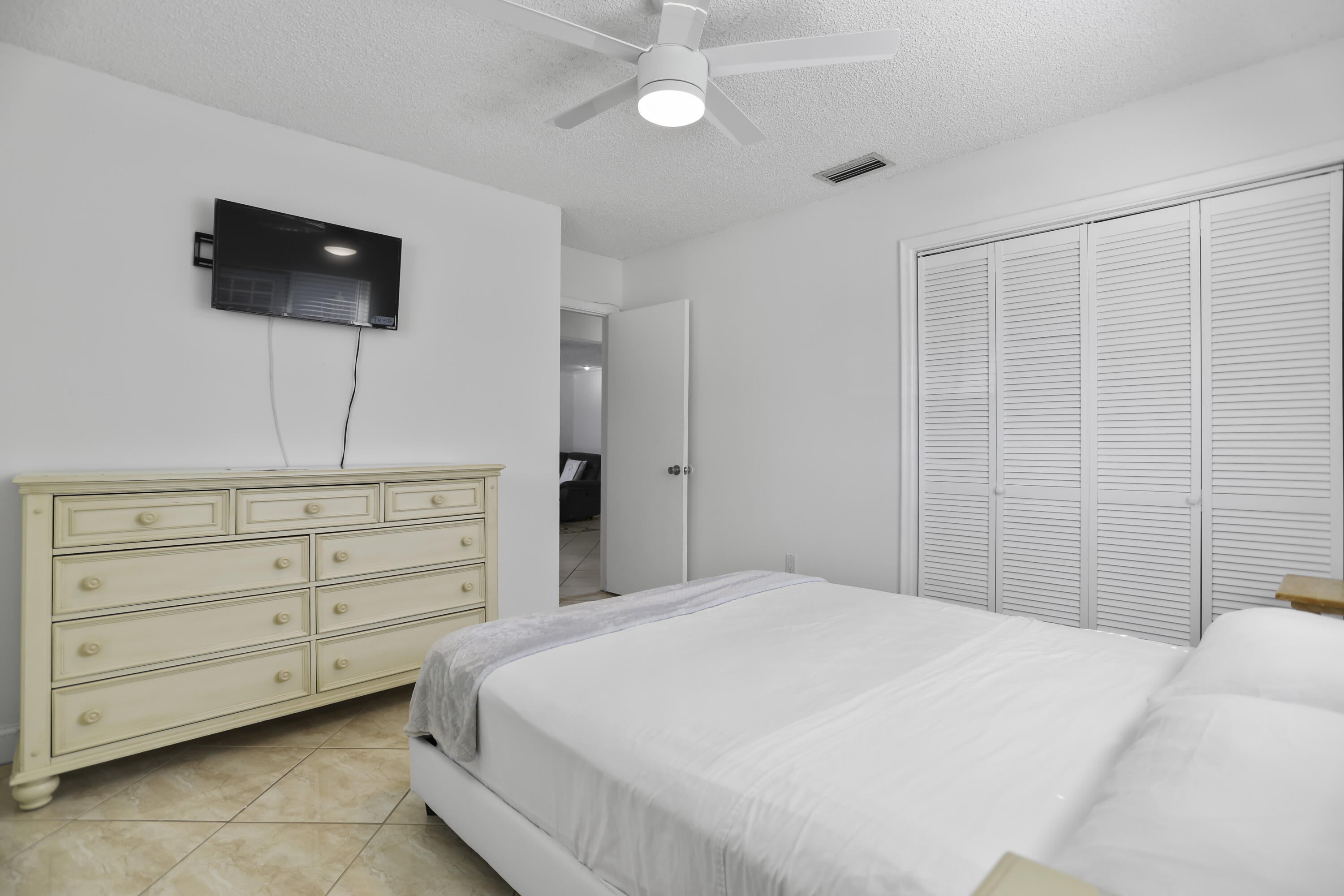 22682 Southwest 65th Avenue Boca Raton, FL 33428 - Photo 31 of 58 a bedroom with a bed and a flat screen tv