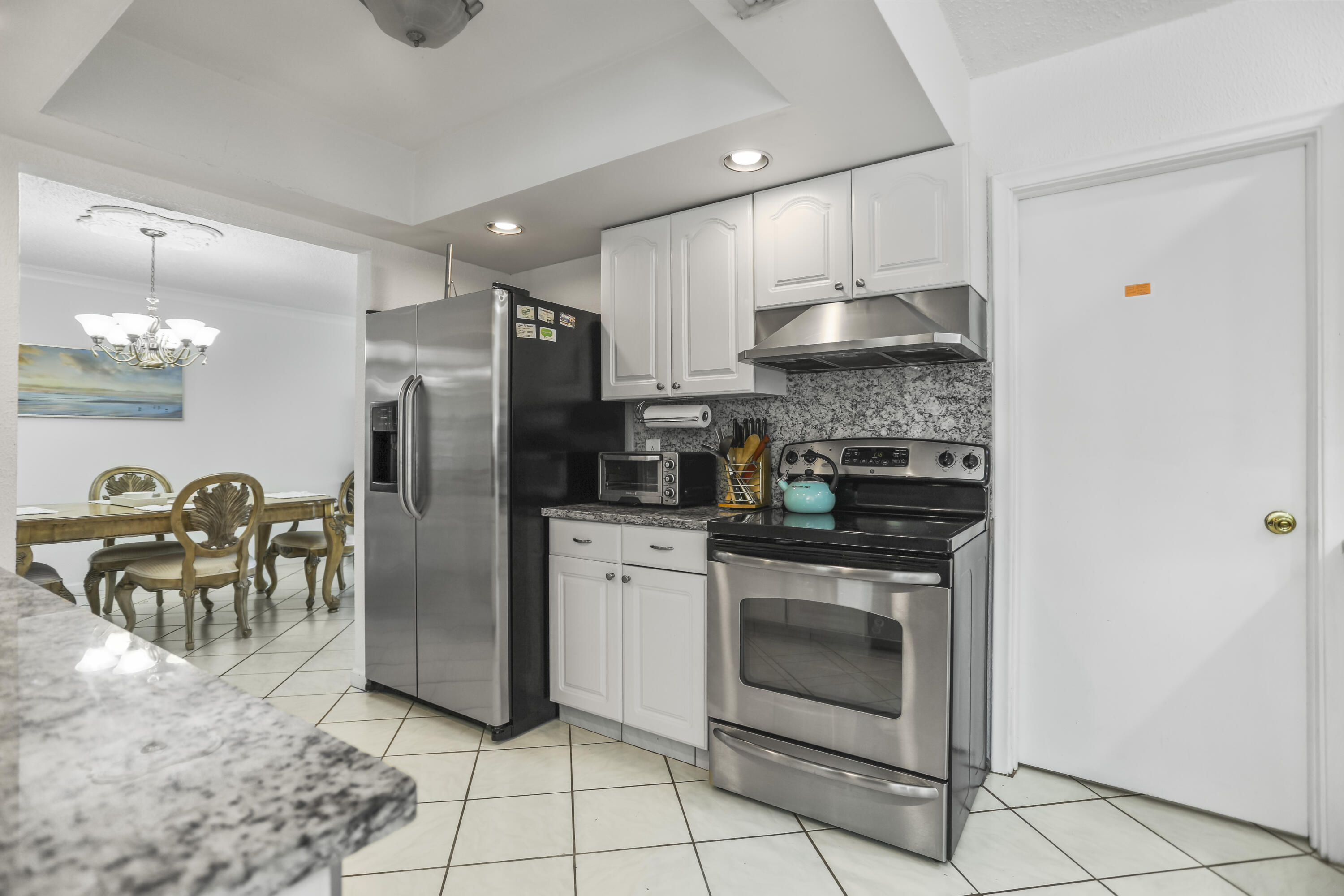 22682 Southwest 65th Avenue Boca Raton, FL 33428 - Photo 9 of 58 a kitchen with granite countertop a stove a refrigerator and a sink