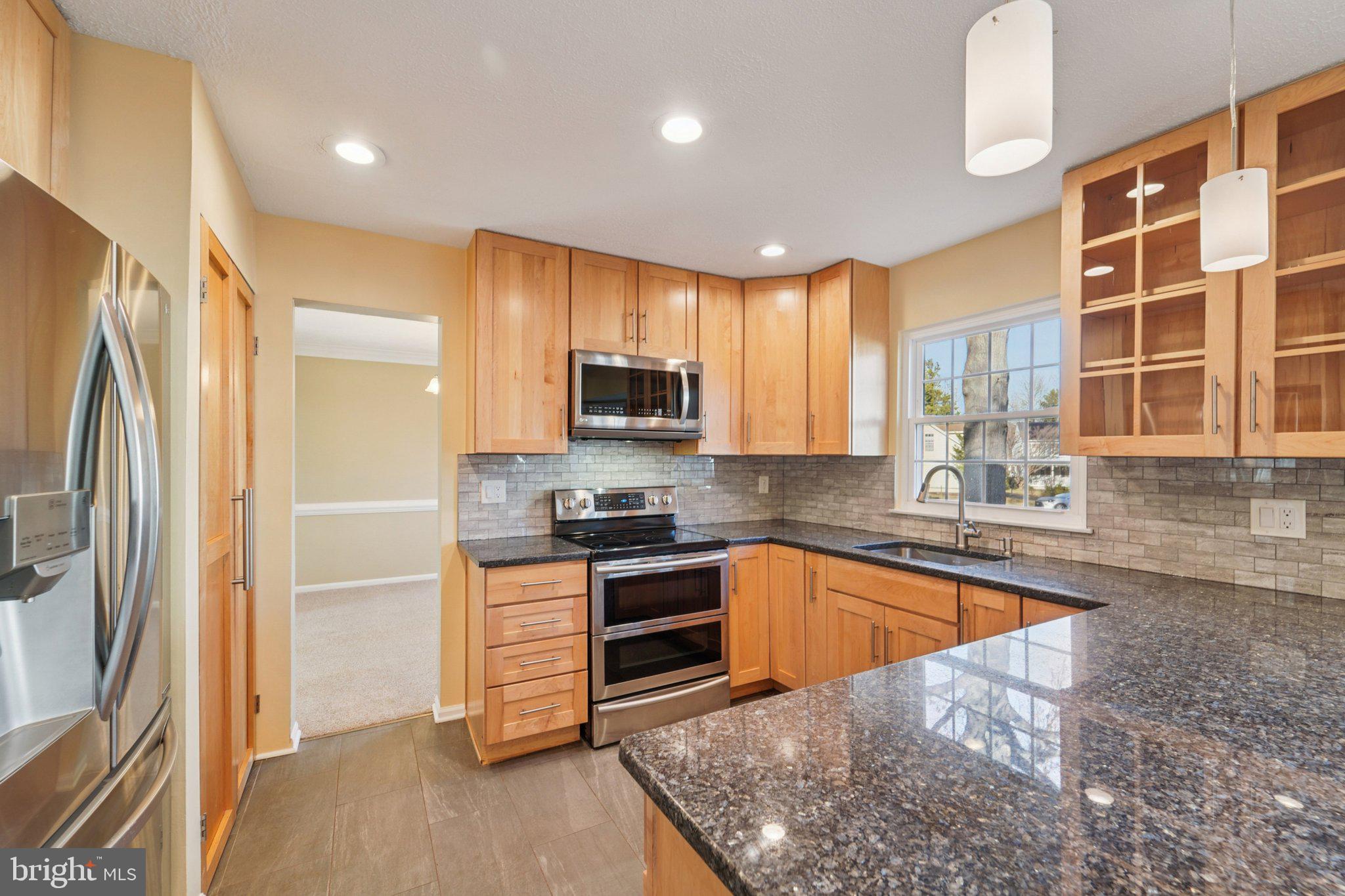 216 Bookham Lane Gaithersburg, MD 20877 - Photo 4 of 49 a kitchen with stainless steel appliances granite countertop a refrigerator a stove a sink and a microwave