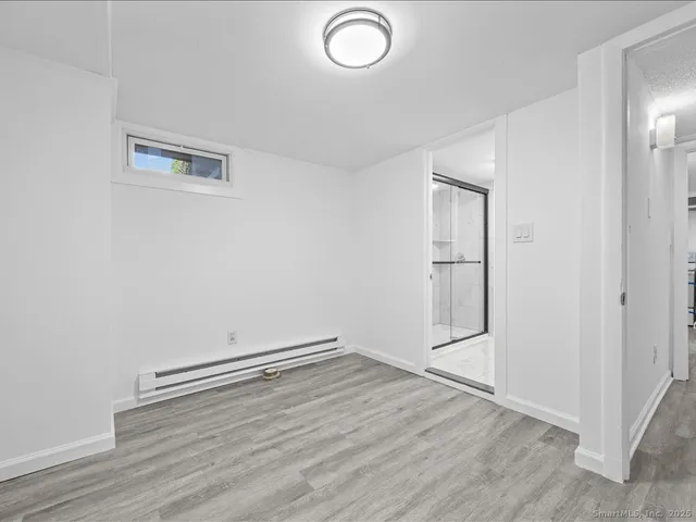 an empty room with wooden floor and mirror