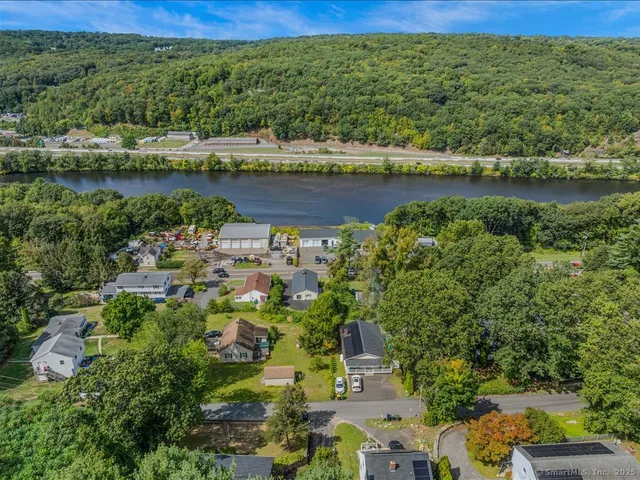 an aerial view of a residential houses with outdoor space and lake view