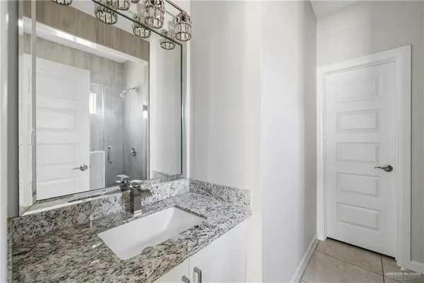 a bathroom with a granite countertop sink and a mirror