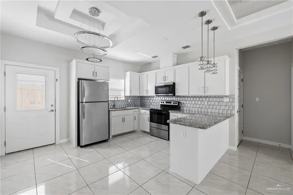 a kitchen with kitchen island granite countertop cabinets and refrigerator