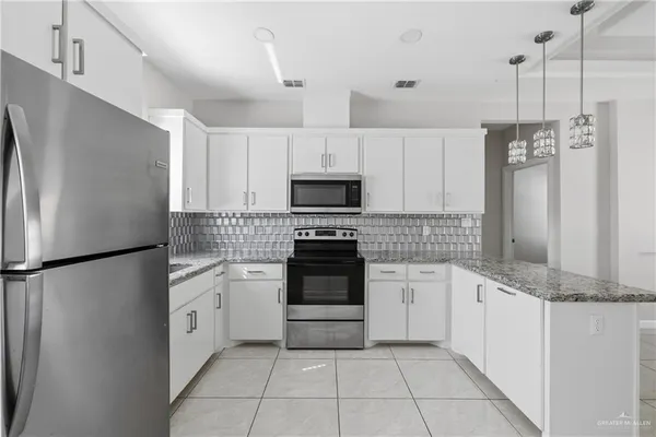 a kitchen with granite countertop white cabinets and stainless steel appliances