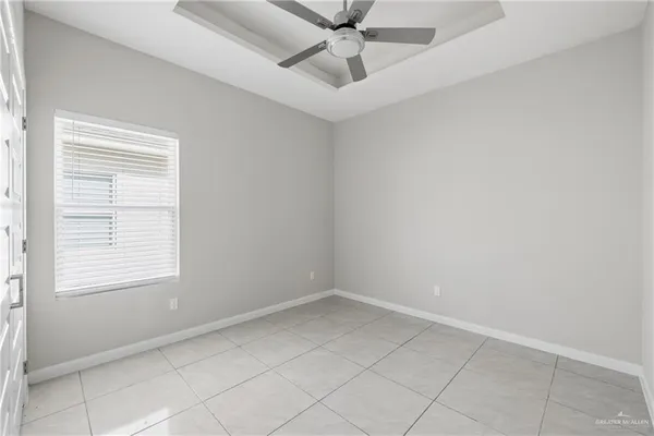 an empty room with a window and a fan