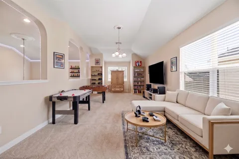 a living room with furniture a chandelier and a fireplace