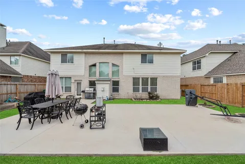a view of a house with patio and a yard