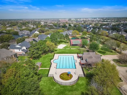 an aerial view of residential house with outdoor space and trees all around