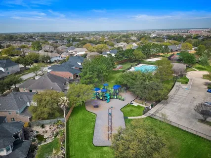 an aerial view of residential houses with outdoor space and ocean view