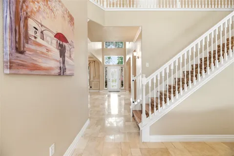 a view of staircase with lots of frames on wall and a large window
