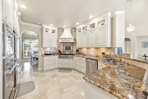 a large kitchen with kitchen island granite countertop a large counter top space appliances and cabinets