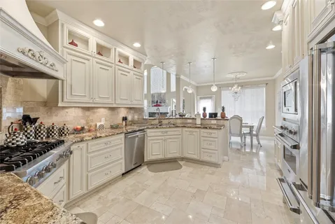a kitchen with white cabinets and appliances