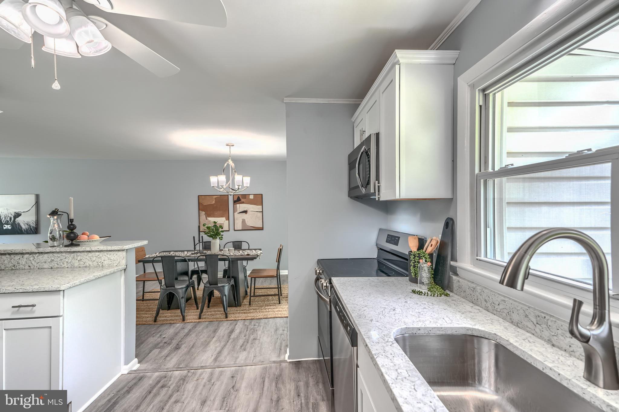 8020 Redstone Road Kingsville, MD 21087 - Photo 10 of 50 a kitchen with a stove a sink a dining table and chairs