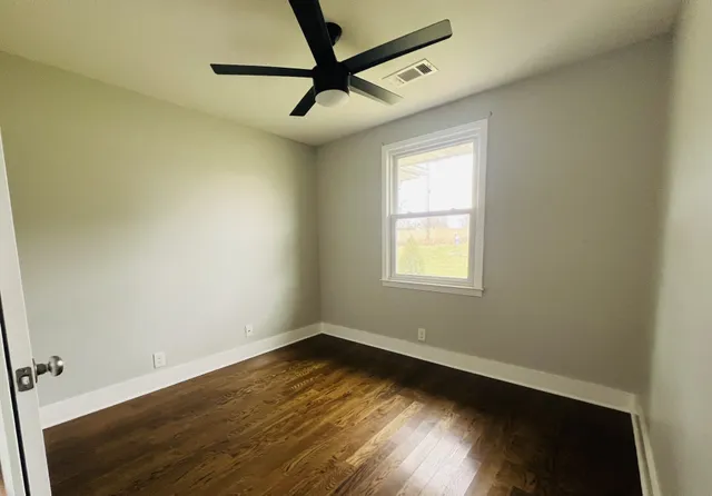 a view of a room with wooden floor and a window