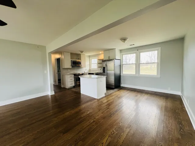 a view of a kitchen with a sink stove cabinets and empty room
