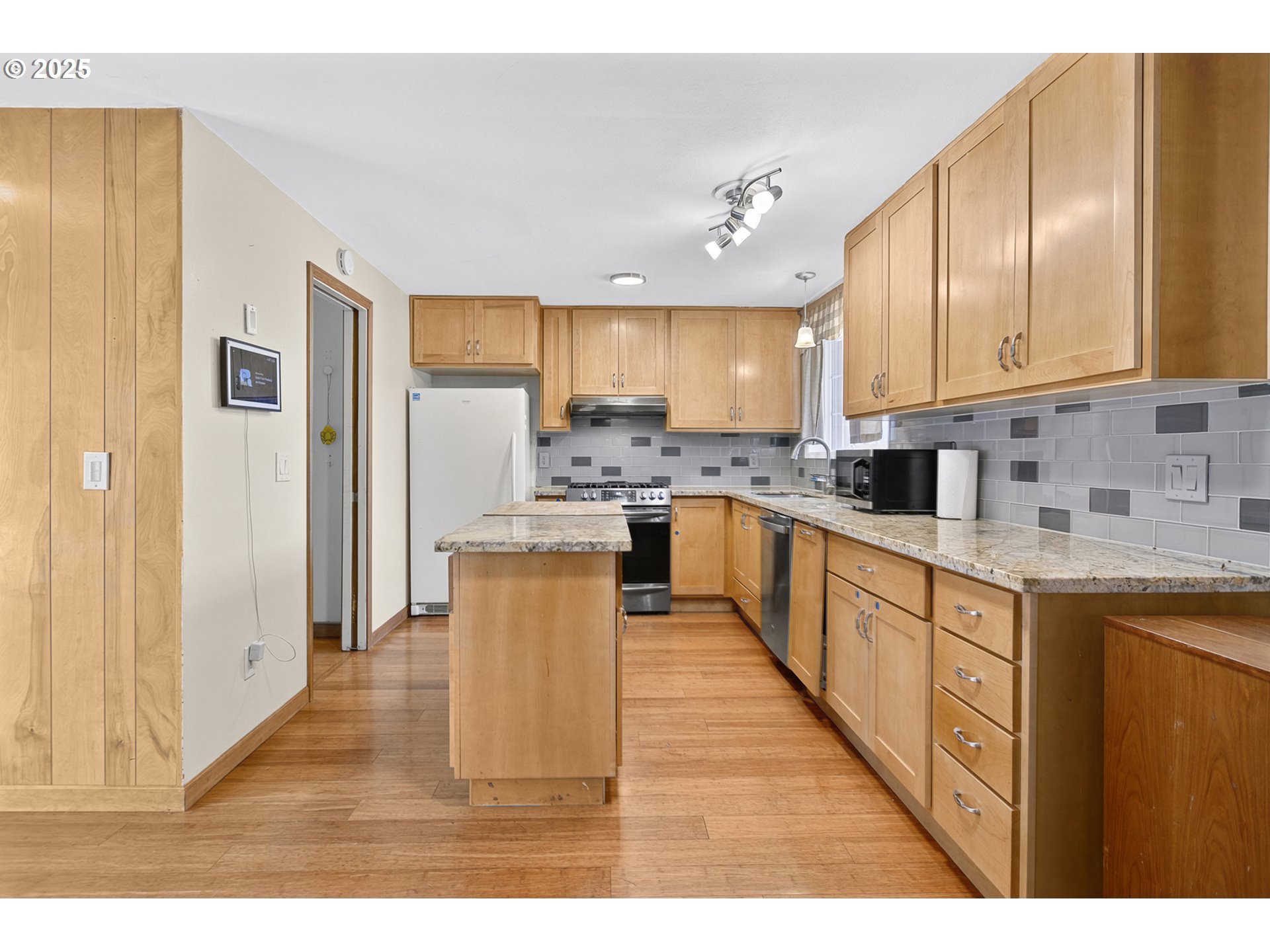 457 Archie Street Eugene, OR 97402 - Photo 12 of 48 a open kitchen with stainless steel appliances granite countertop a stove top oven a sink dishwasher and a refrigerator with wooden floor