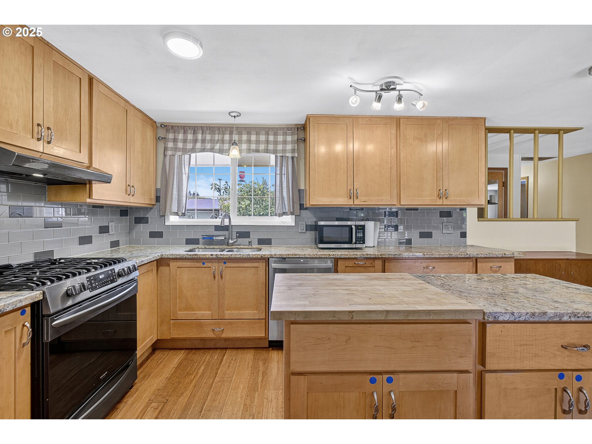 457 Archie Street Eugene, OR 97402 - Photo 3 of 48 a kitchen with a stove a sink a microwave and cabinets