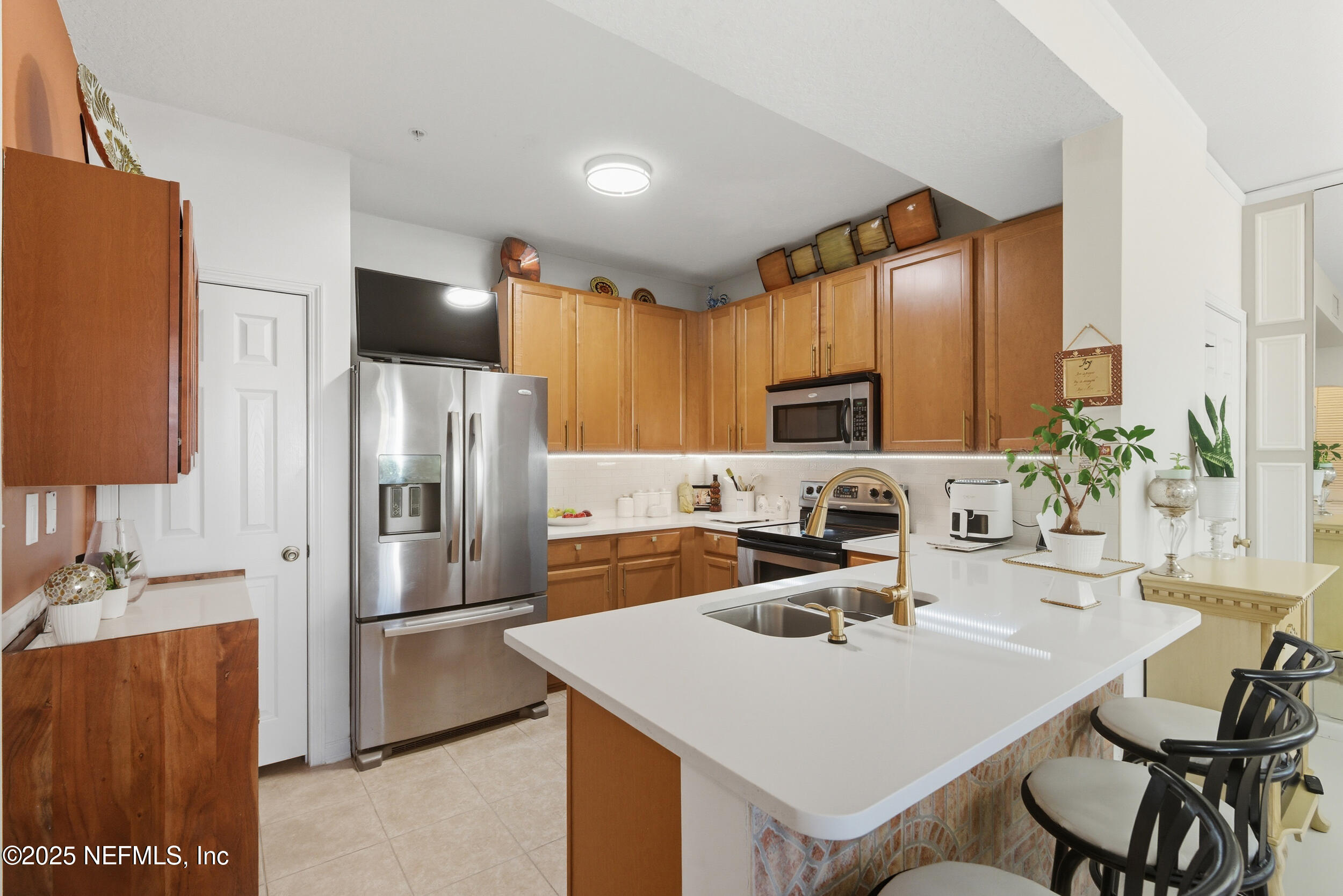 575 Oakleaf Plantation Parkway, Unit 1004 Orange Park, FL 32065 - Photo 1 of 22 a kitchen with stainless steel appliances a sink a counter top space cabinets and a refrigerator
