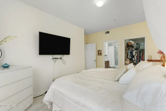 a bedroom with a bed and a flat screen tv
