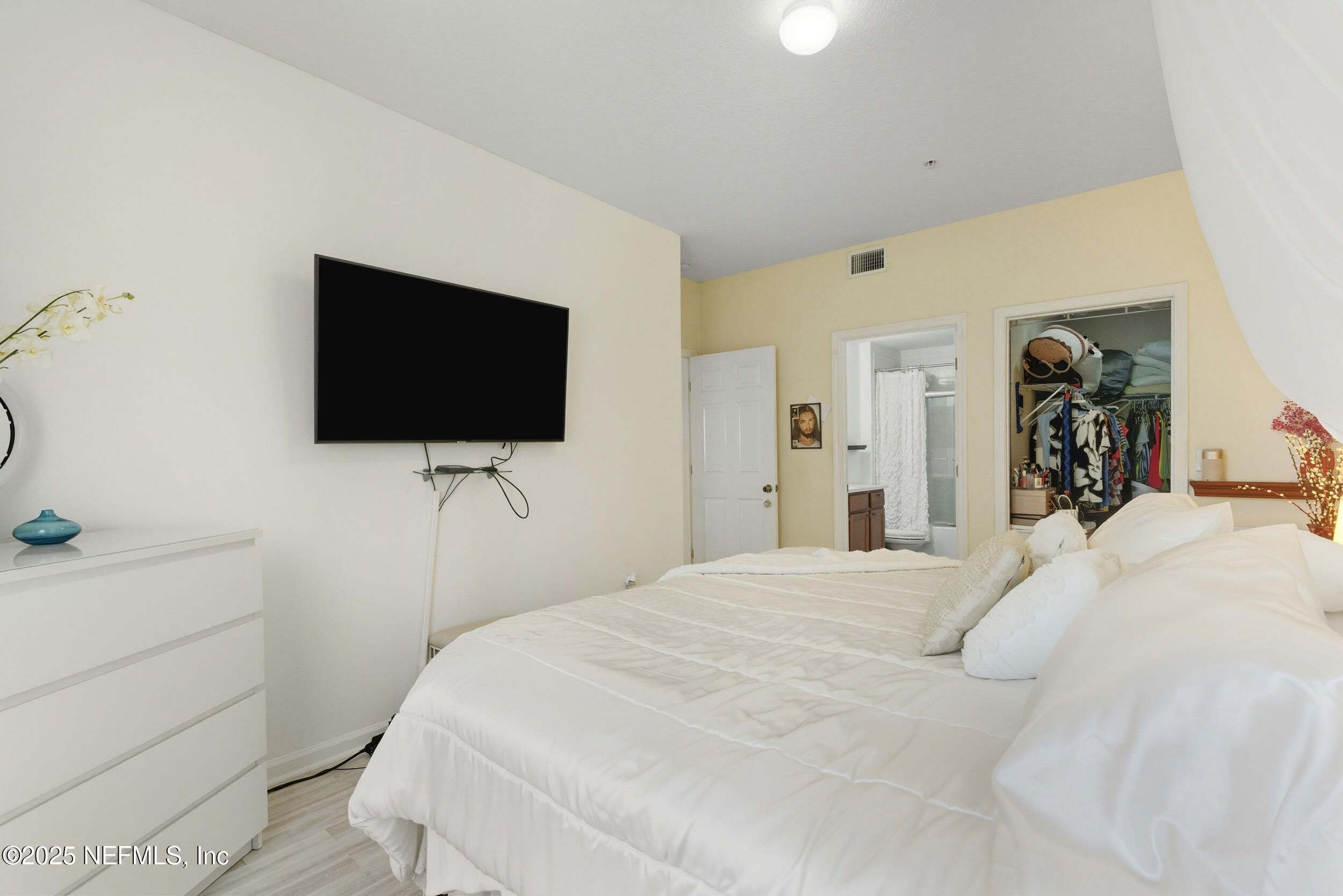575 Oakleaf Plantation Parkway, Unit 1004 Orange Park, FL 32065 - Photo 13 of 22 a bedroom with a bed and a flat screen tv
