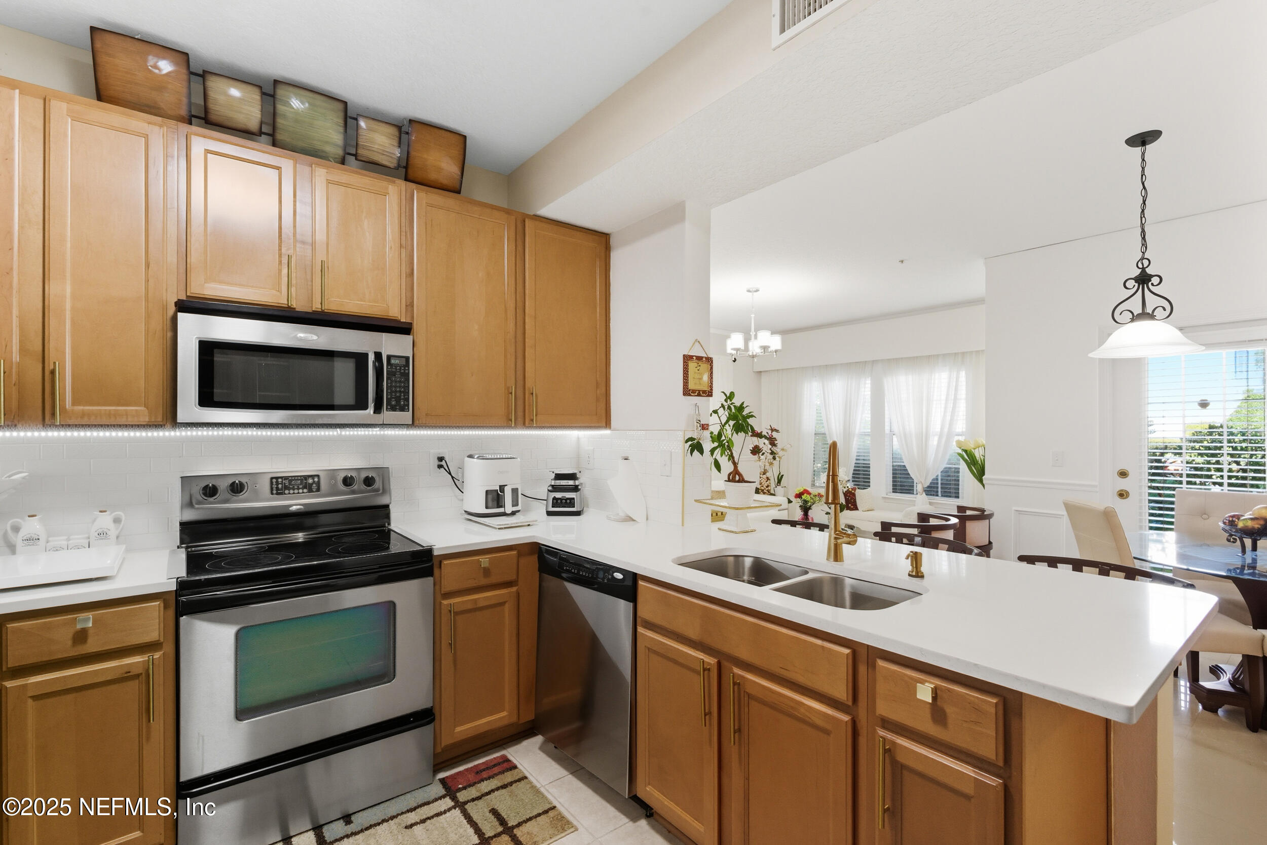 575 Oakleaf Plantation Parkway, Unit 1004 Orange Park, FL 32065 - Photo 3 of 22 a kitchen with a sink stove and microwave