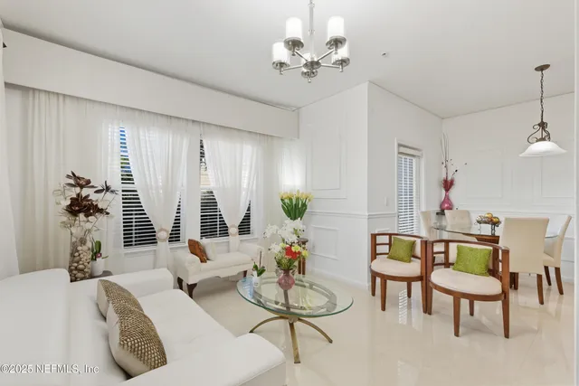 a living room with furniture and a chandelier