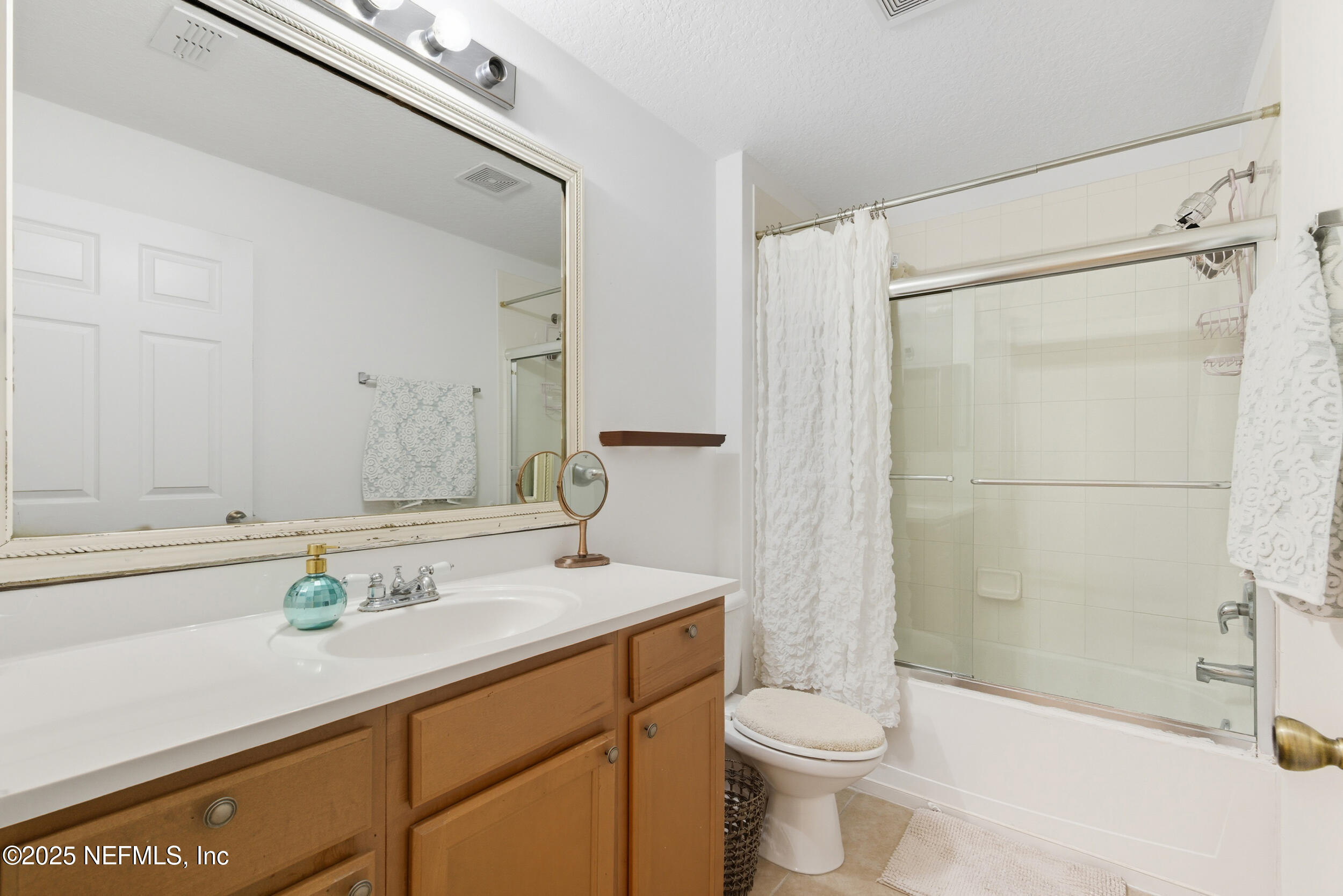 575 Oakleaf Plantation Parkway, Unit 1004 Orange Park, FL 32065 - Photo 8 of 22 a bathroom with a sink a toilet and shower