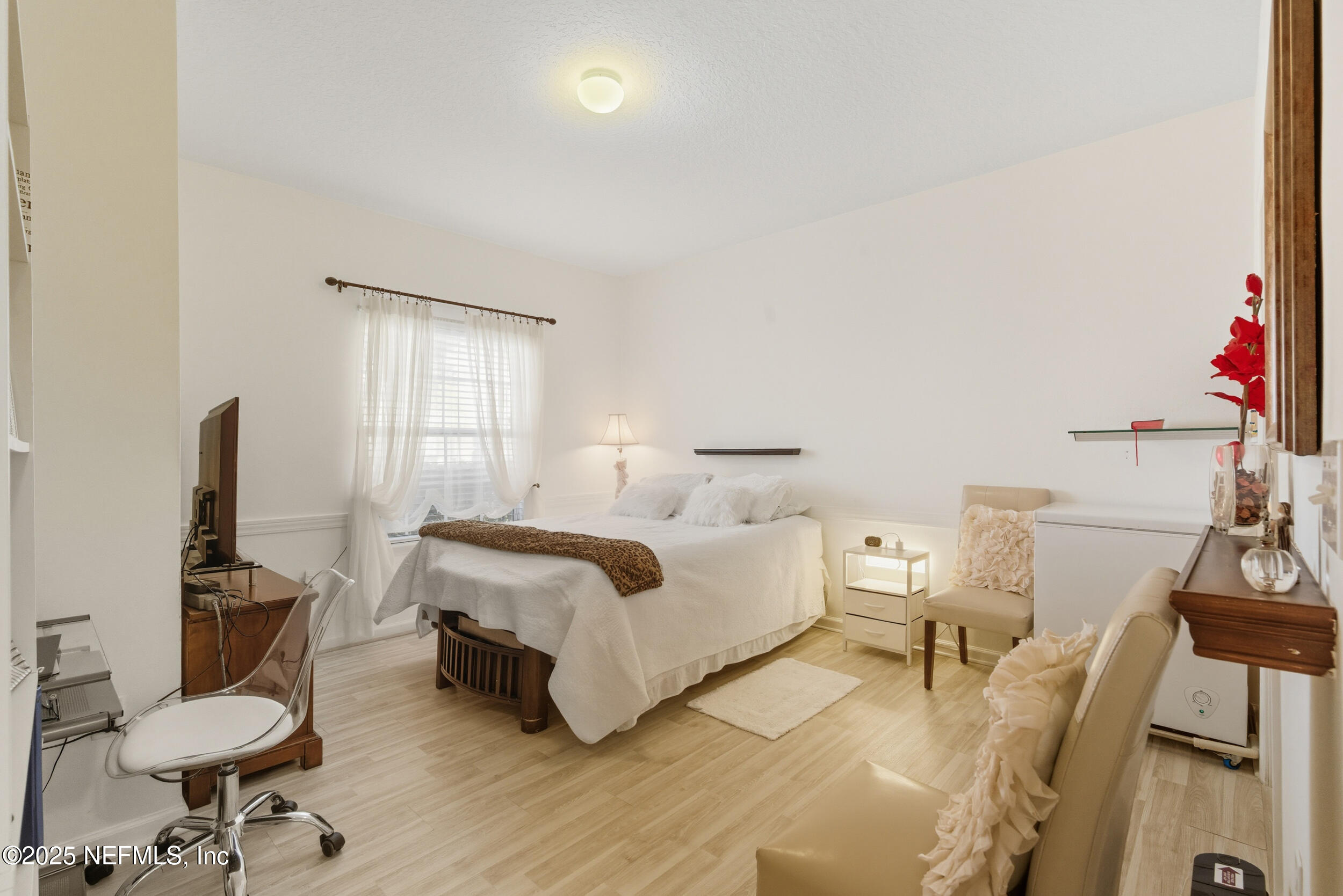 575 Oakleaf Plantation Parkway, Unit 1004 Orange Park, FL 32065 - Photo 9 of 22 a spacious bedroom with a bed a couch and wooden floor