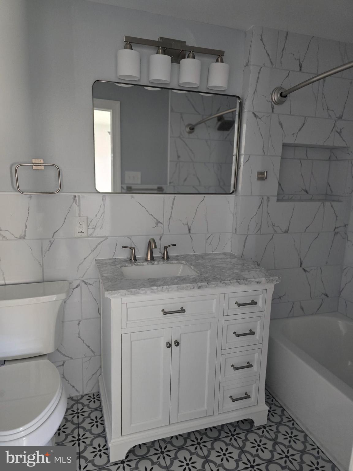 5925 Ridge Avenue, Unit 5 Philadelphia, PA 19128 - Photo 25 of 31 a bathroom with a granite countertop sink a toilet and bathtub