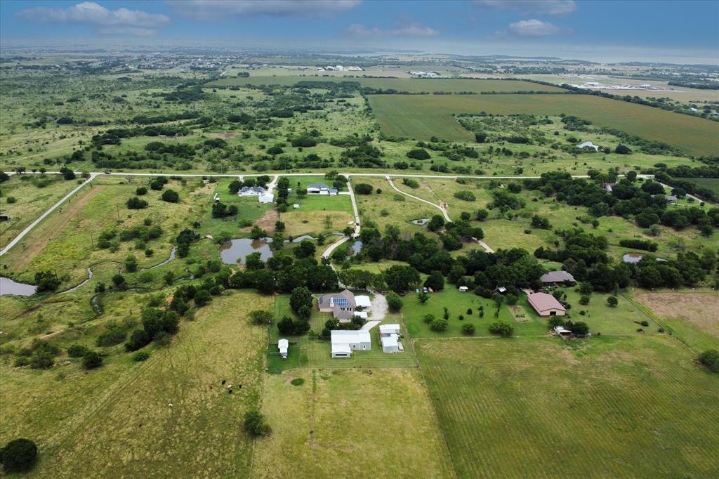 3007 McReynolds Road Sanger, TX 76266 - Photo 37 of 39 Expansive aerial rendering showcasing multiple residential structures, diverse cultivated fields, and natural waterways