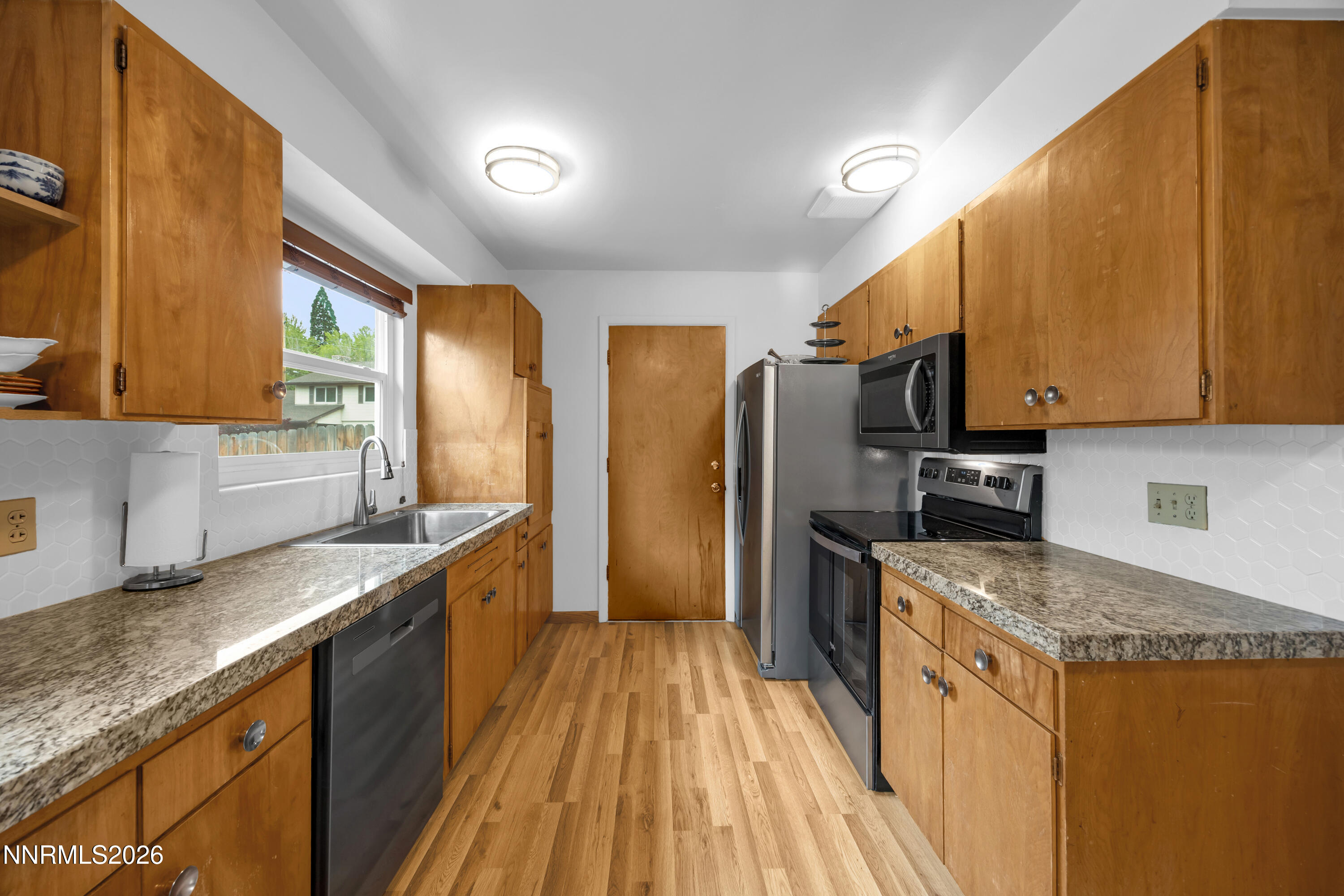 1208 Charles Drive Reno, NV 89509 - Photo 18 of 36 a kitchen with stainless steel appliances granite countertop wooden cabinets a refrigerator and a sink