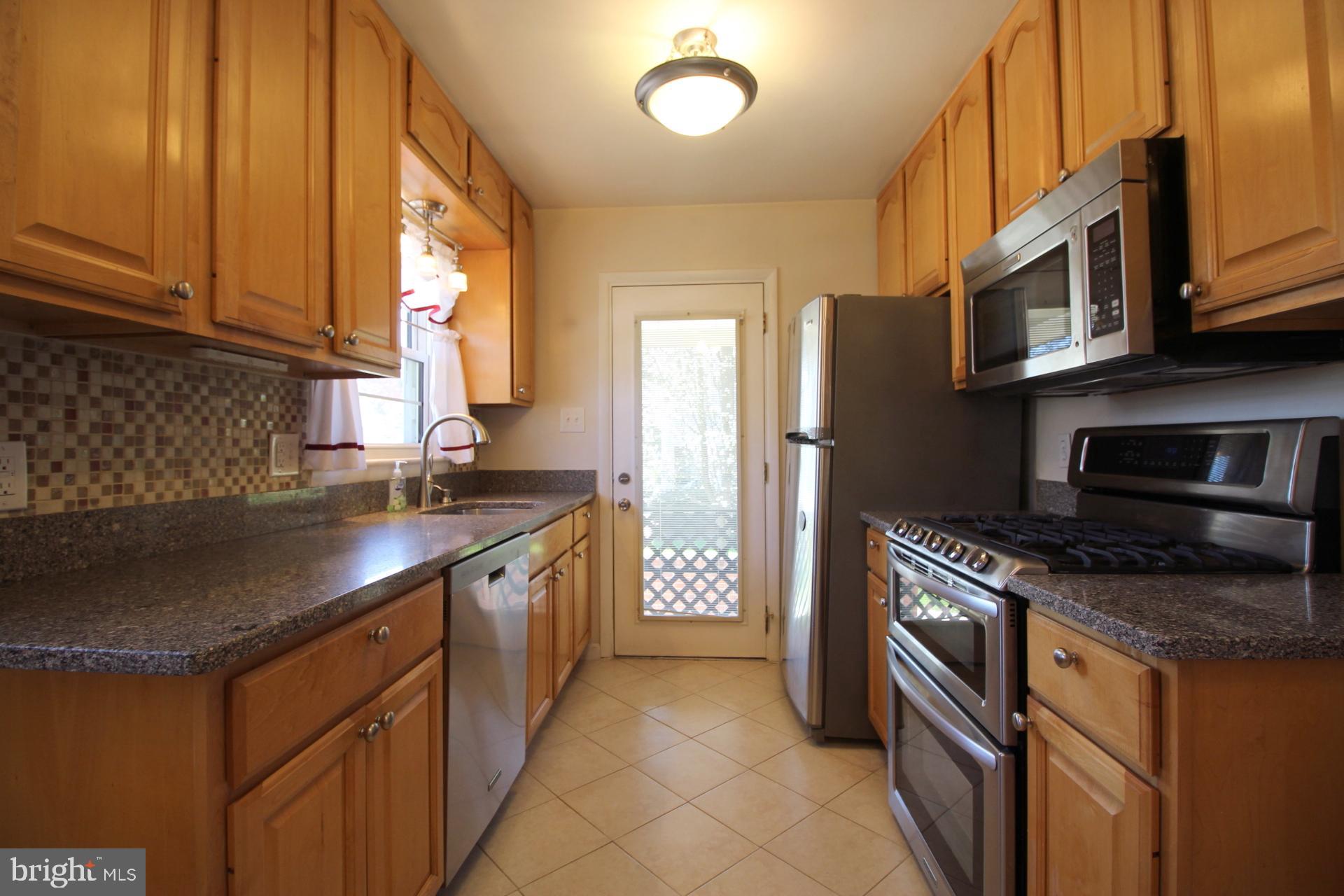 8504 Wagon Wheel Road Alexandria, VA 22309 - Photo 11 of 30 a kitchen with stainless steel appliances granite countertop a sink stove and refrigerator