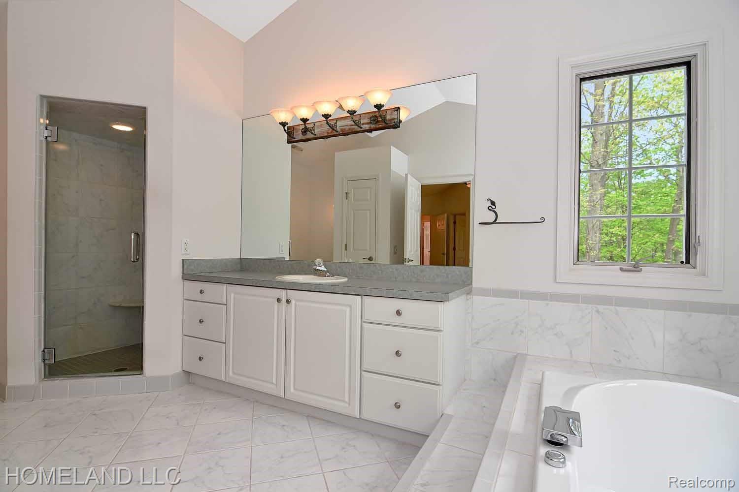 13631 Neal Road Davisburg, MI 48350 - Photo 24 of 26 master bathroom with walk in shower and whirl pool tub