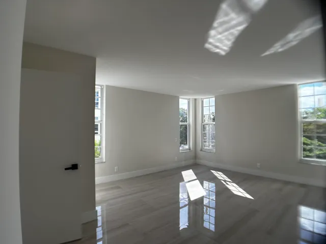 a view of a livingroom with lounge chair and windows