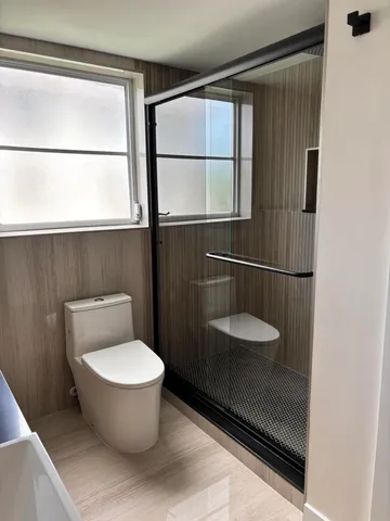 a bathroom with a granite countertop toilet and a sink