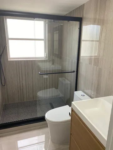 a bathroom with a sink a toilet and shower
