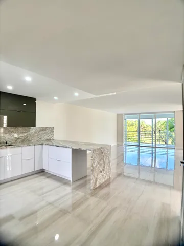 a large kitchen with granite countertop a large window and a sink