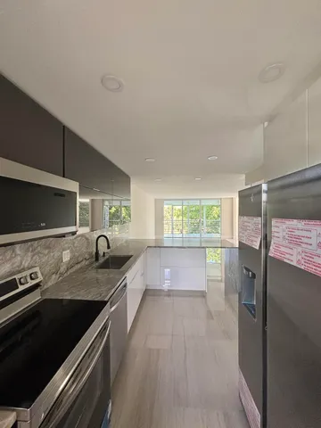 a kitchen with a sink stove and refrigerator