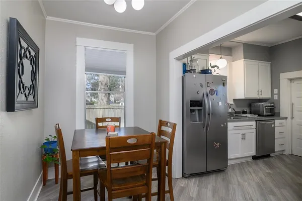 a kitchen with stainless steel appliances a refrigerator a stove a dining table and chairs