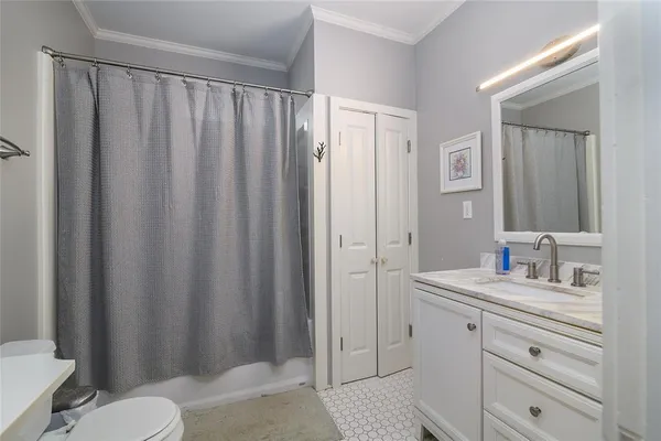 a bathroom with a sink a toilet a mirror and shower curtain