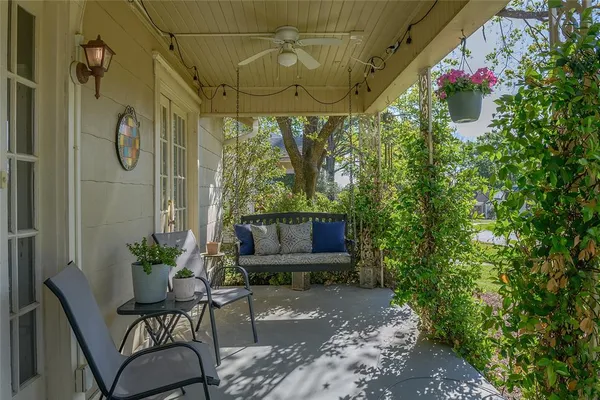 a view of a porch with a table and chairs and potted plants